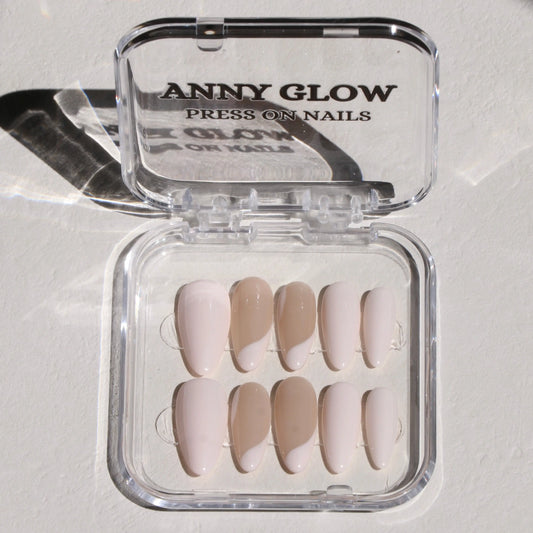 A set of press-on nails in a clear plastic box, featuring an ivory white color with a glossy finish and a chic, transparent nude accent.