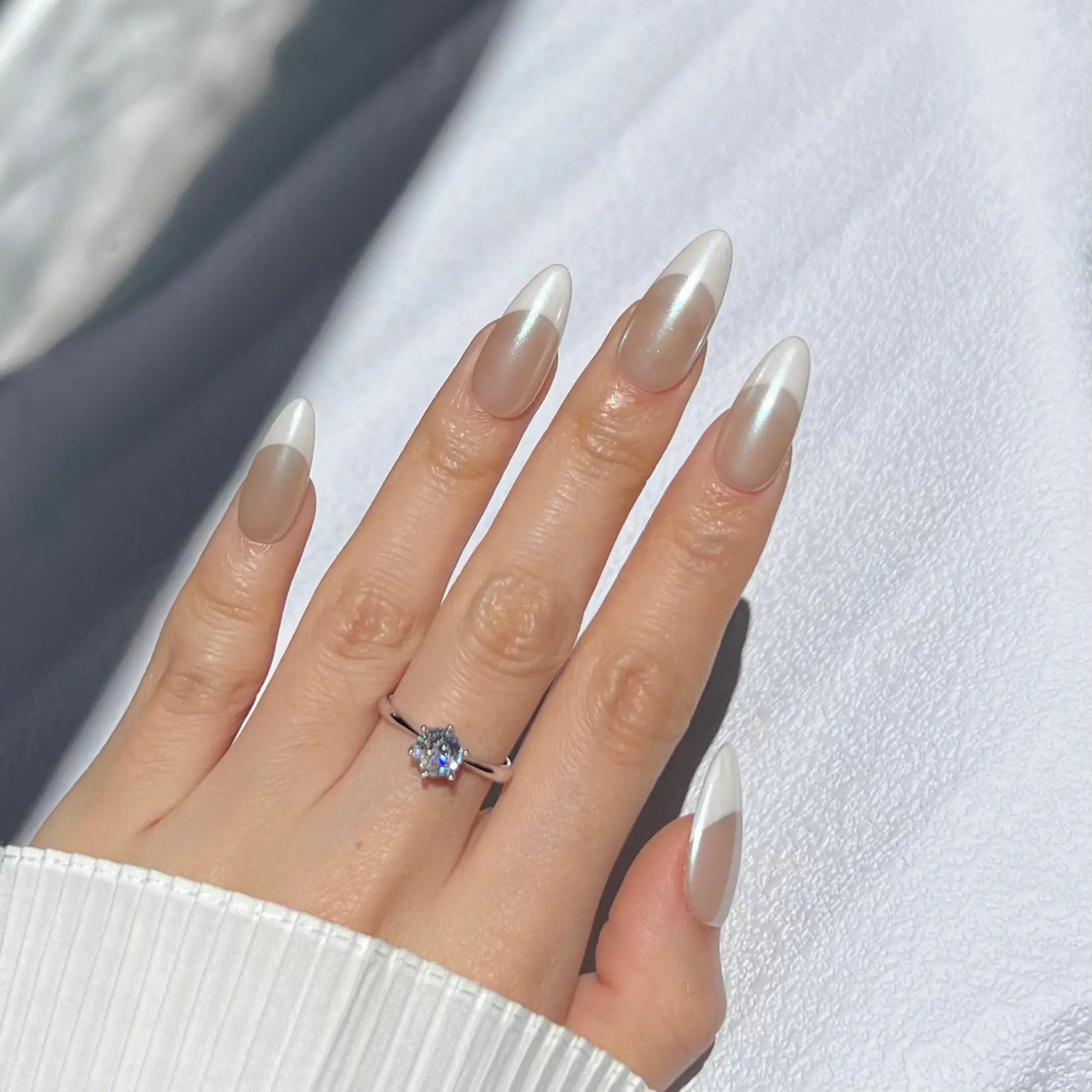 Another view of the hand showcasing the Pearl French nails with white, shimmering tips, creating a timeless and elegant appearance.